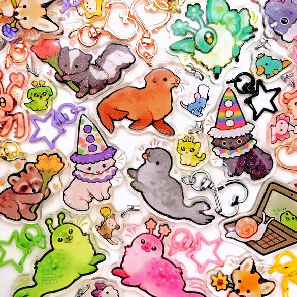 Picture of an assortment of acrylic keychains featuring cats, raccoons, sea lions, seals, and more.